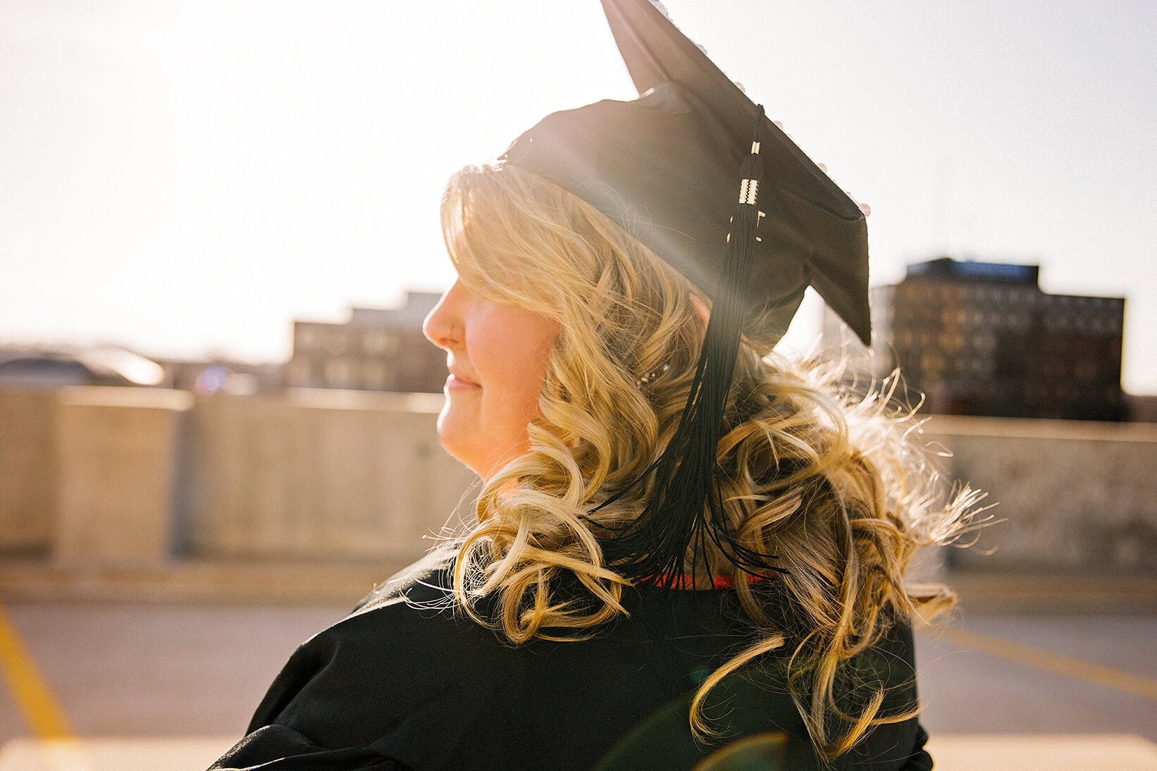 Woman wearing a graduation cap in front of a sunset